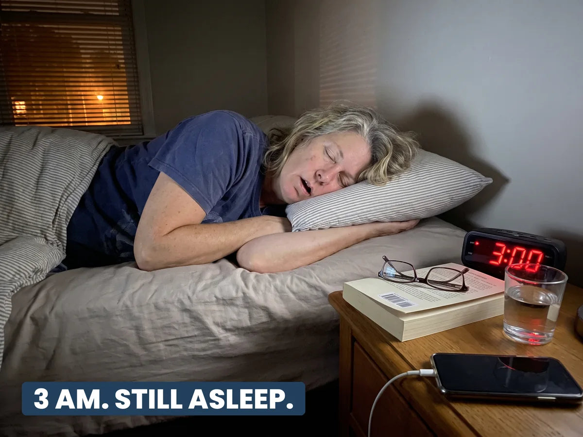 A woman fast asleep at 3 AM, the bedside clock showing 3:00