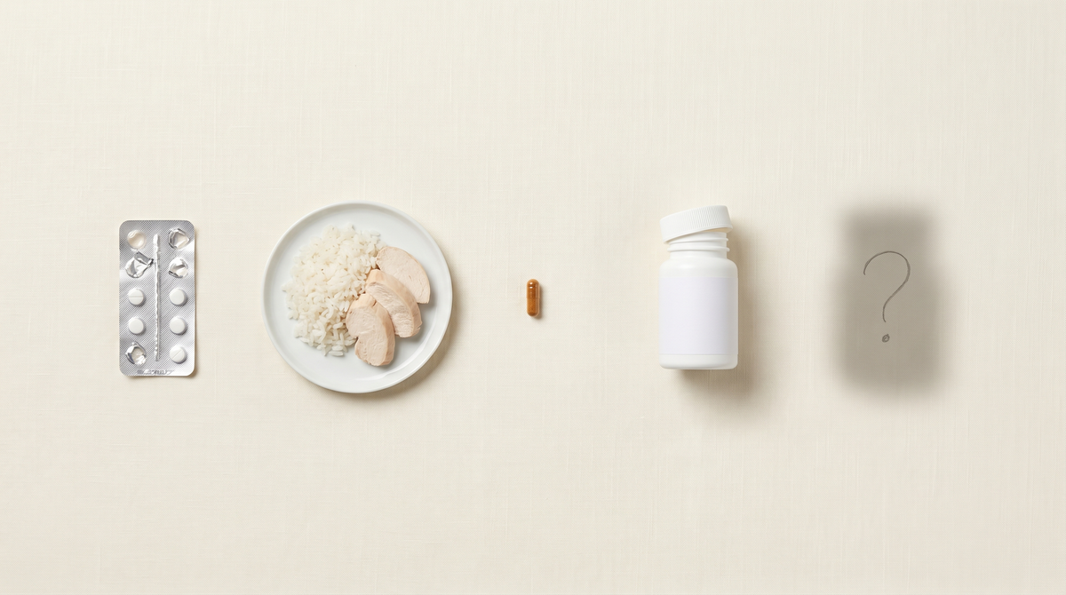 Half-empty supplement bottles and prescription bottles lined up on a kitchen counter, antihistamines, SSRIs, probiotics, low-histamine diet book