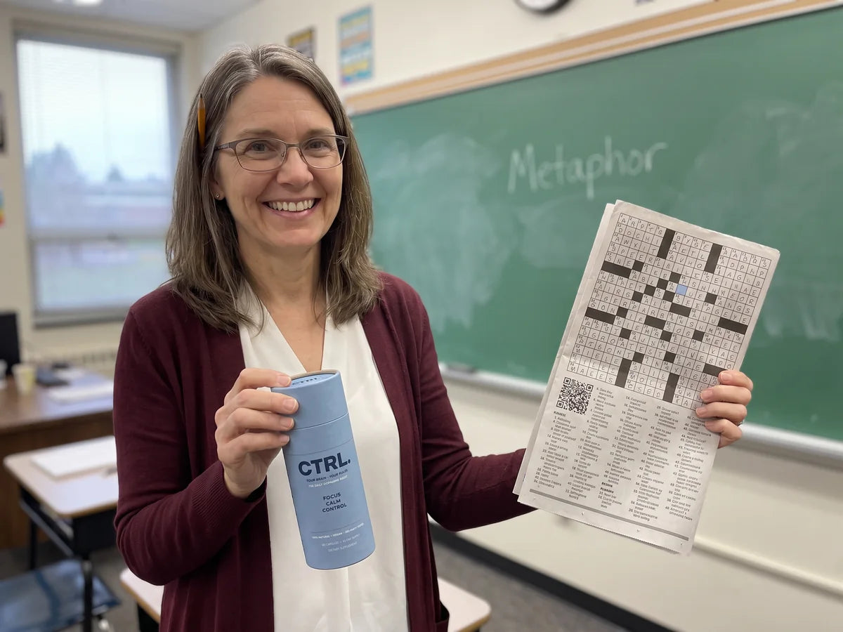 Linda smiling in her classroom, holding CTRL and a finished crossword