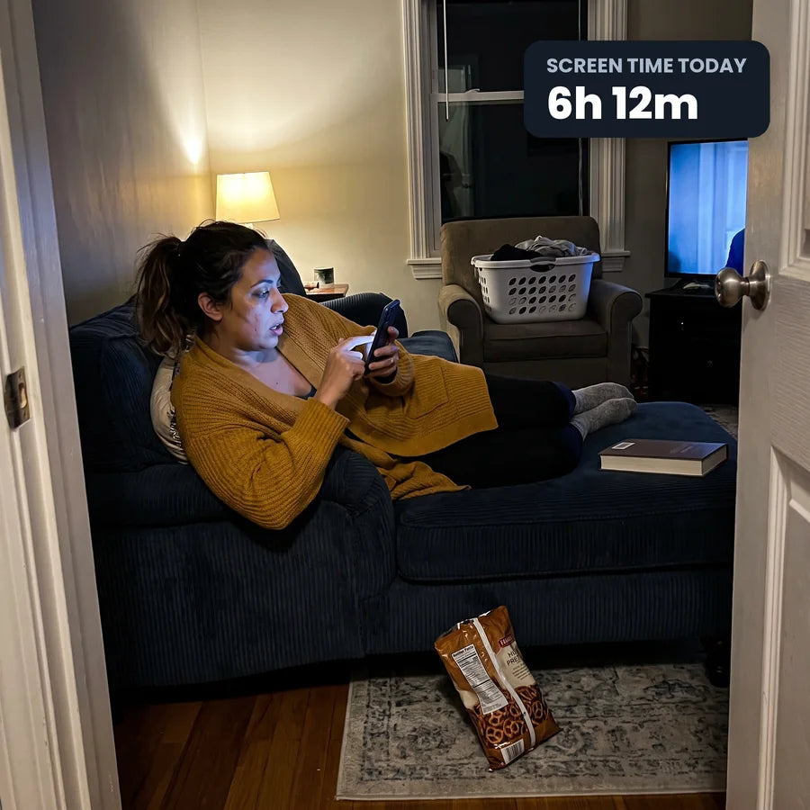 Woman lost on her phone on the sofa at night, screen time 6 hours 12 minutes