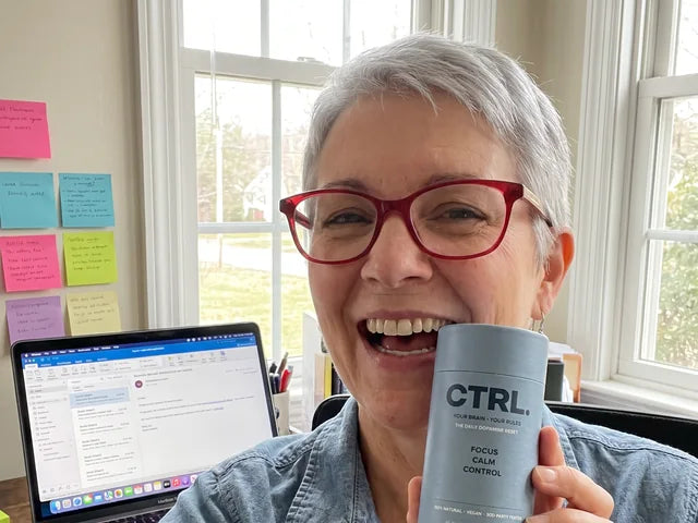 Barbara T., a CTRL customer in her fifties, holding her CTRL tube at her desk